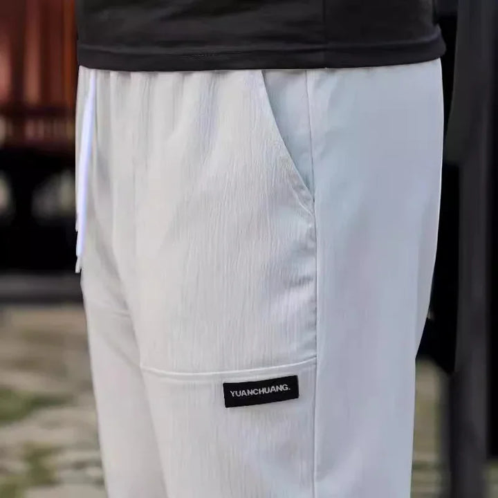White casual pants with side pocket and black 'YUANCHUANG' label, worn with black top