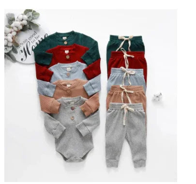 Set of cozy baby bodysuits and matching pants in green, red, blue, brown, and gray knit fabrics