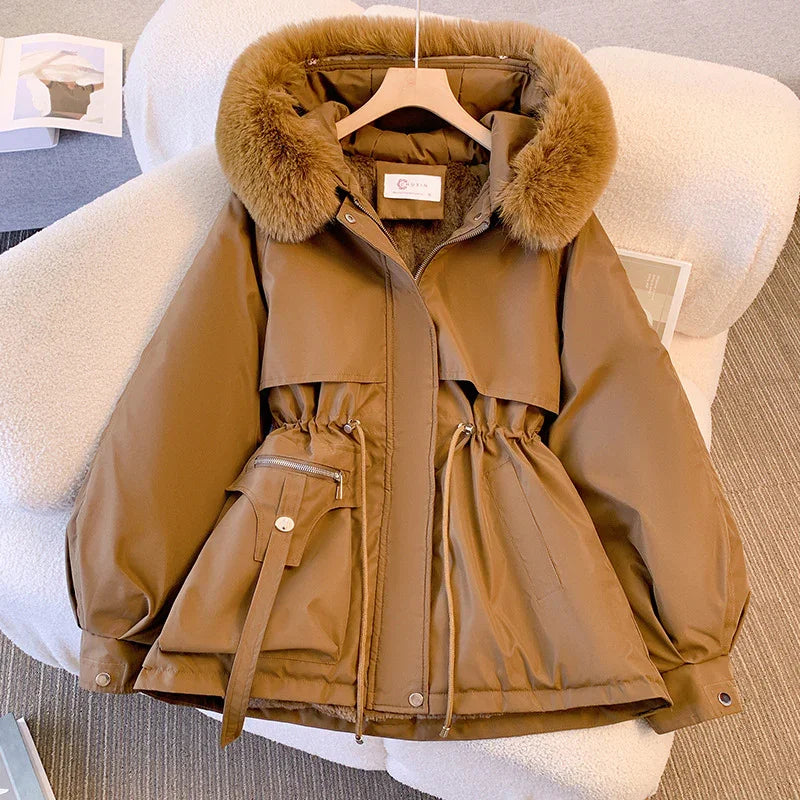Brown winter jacket with fur collar, adjustable waist, and large front pockets on white chair