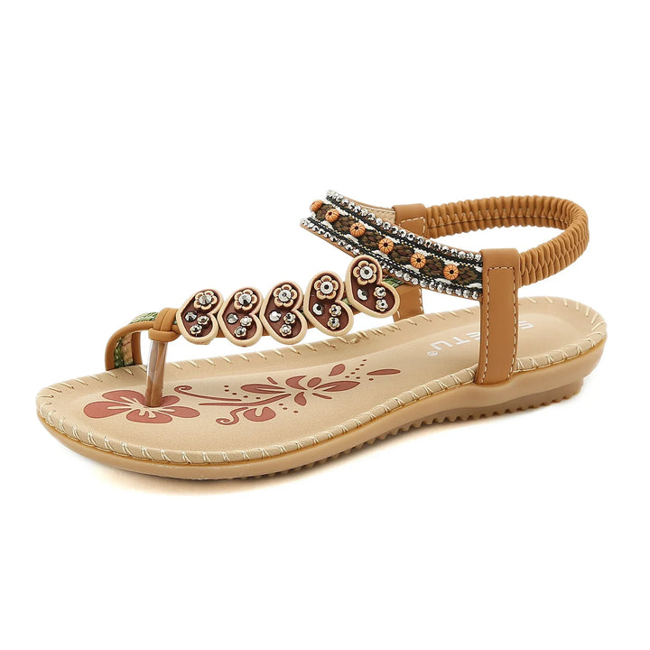 Brown women's sandal with floral decorations and beaded ankle strap on beige sole