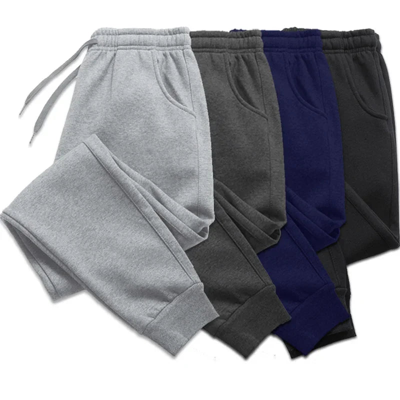 Set of four fleece jogger sweatpants in gray, dark gray, navy blue, and black with elastic cuffs and drawstring waist