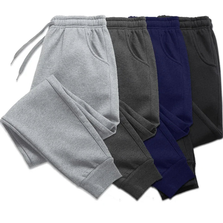 Set of four fleece jogger sweatpants in gray, dark gray, navy blue, and black with elastic cuffs and drawstring waist