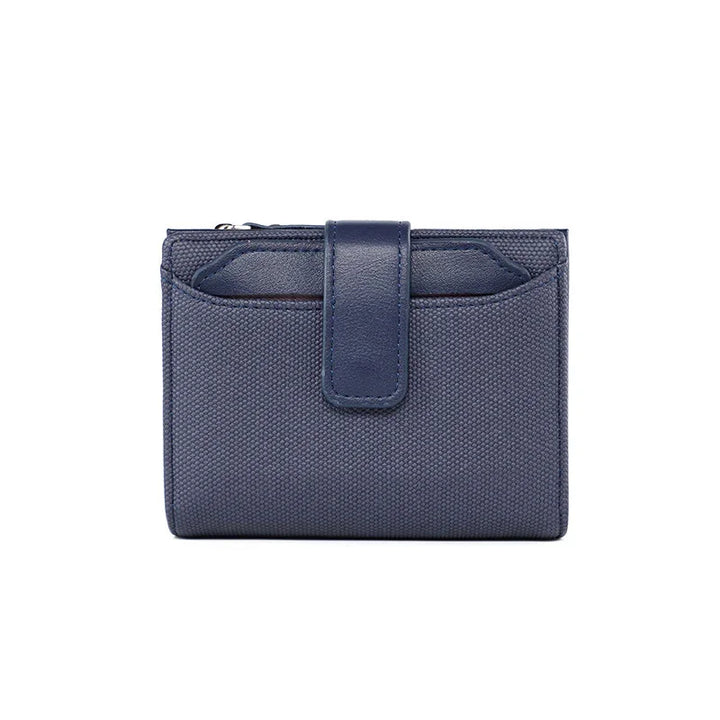 Compact navy blue textured fabric wallet with leather strap closure on white background