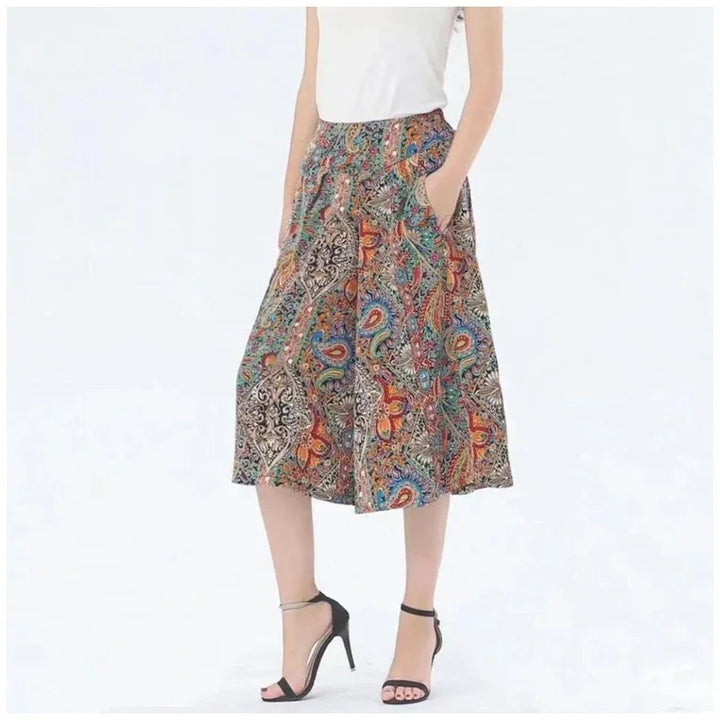 Woman wearing colorful paisley print midi skirt with pockets and black high heel sandals