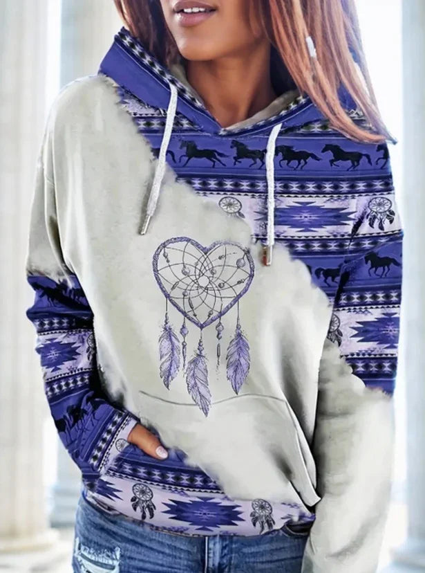 Woman wearing hoodie with purple Native American patterns, horses, and heart-shaped dreamcatcher design