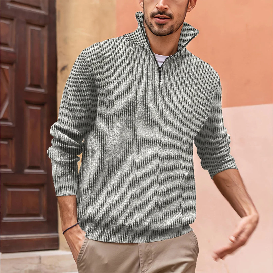 man wearing gray ribbed quarter-zip sweater and beige pants in outdoor setting