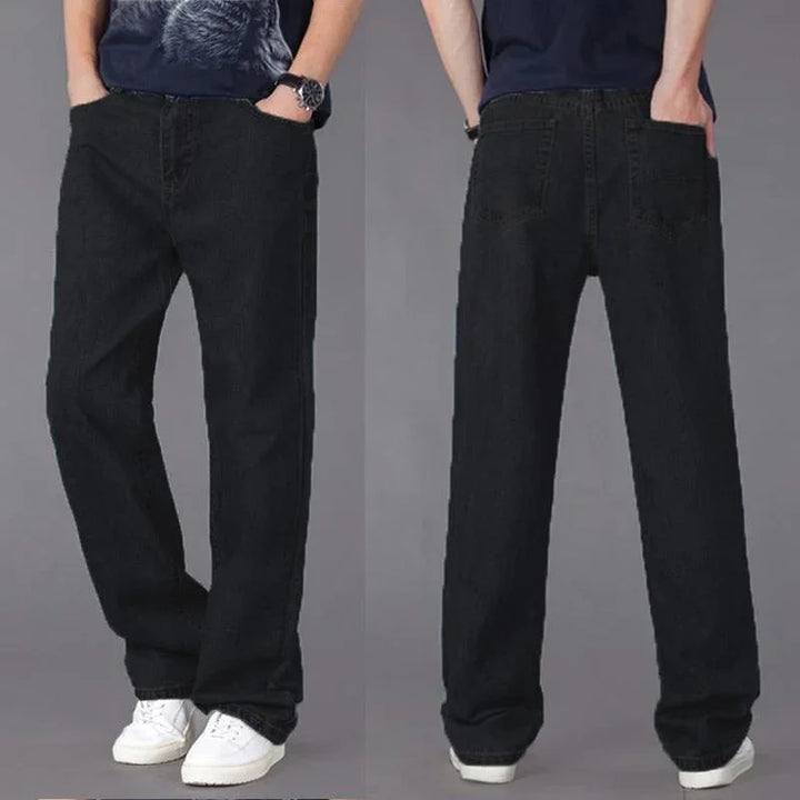 Front and back view of black relaxed fit jeans worn with white sneakers and dark graphic t-shirt