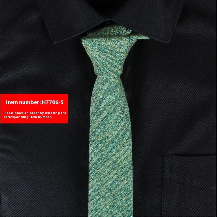 Close-up of a green textured necktie on a black collared shirt with item number H7706-5 label
