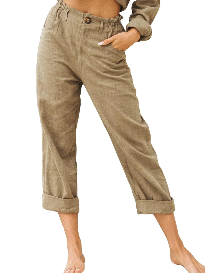 Woman wearing high-waisted beige cuffed pants with pockets and button detail