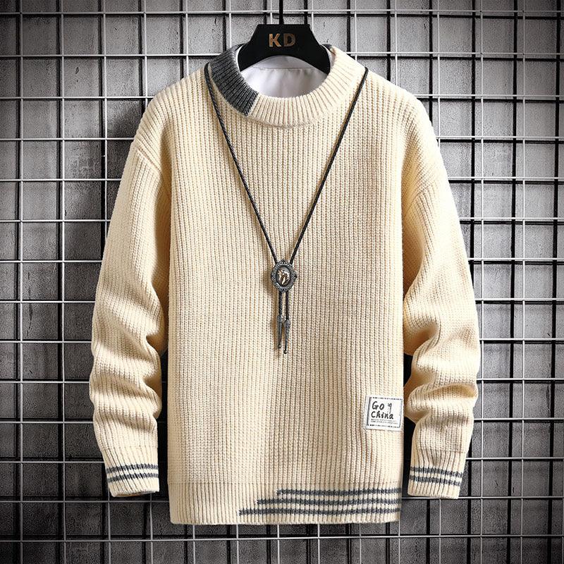 Beige ribbed knit sweater with gray collar and cuff stripes, decorative patch, and hanging pendant necklace