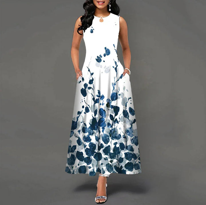 Woman wearing white sleeveless maxi dress with blue floral print and side pockets