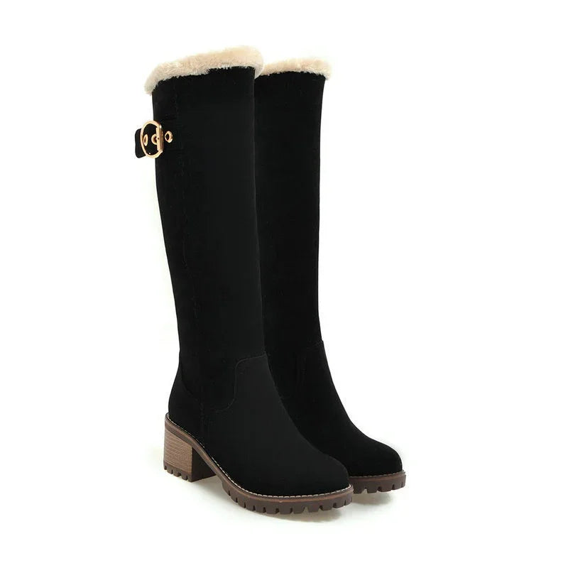 Black knee-high winter boots with faux fur trim and chunky brown heels and soles
