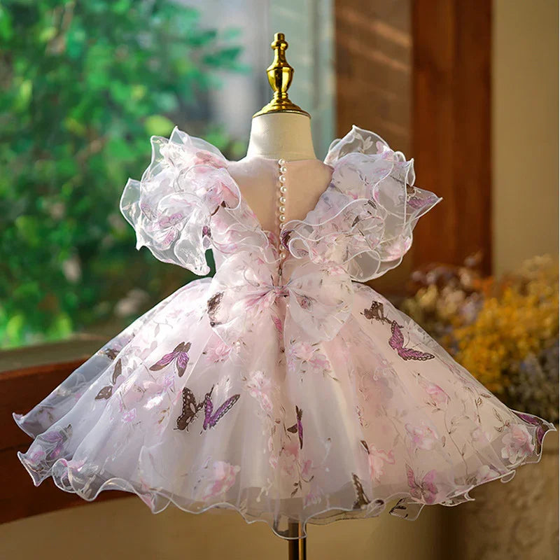 Elegant children's dress with ruffled sheer sleeves and butterfly print on a mannequin