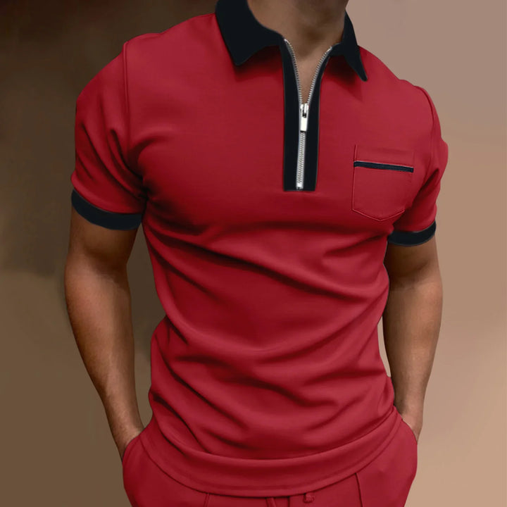 Men's red short sleeve polo shirt with black collar, zipper, and pocket trim against neutral background