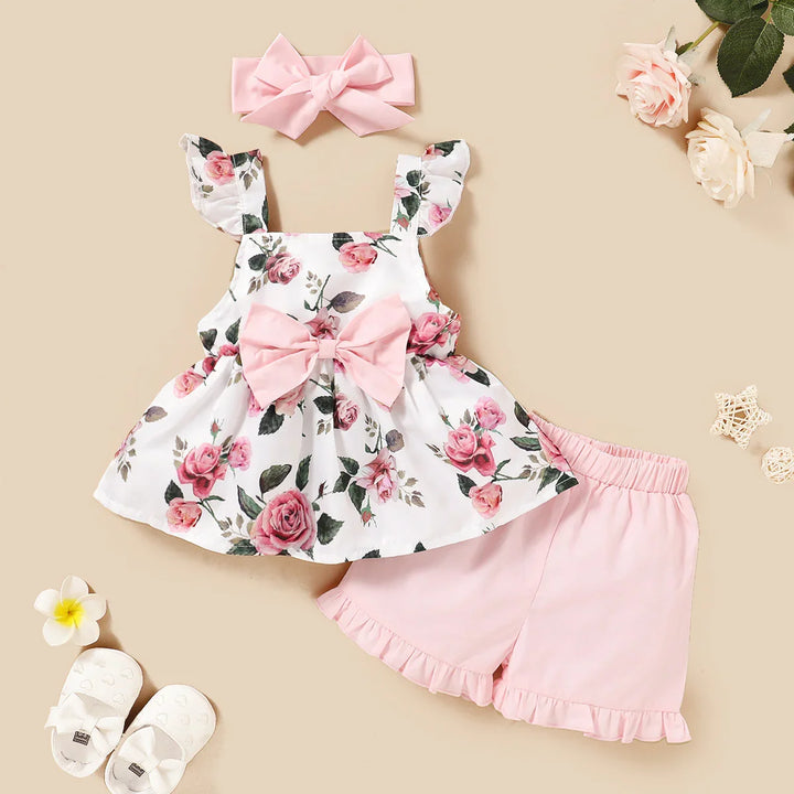 Baby floral sleeveless top with ruffles, pink bow, matching pink shorts, and headband set