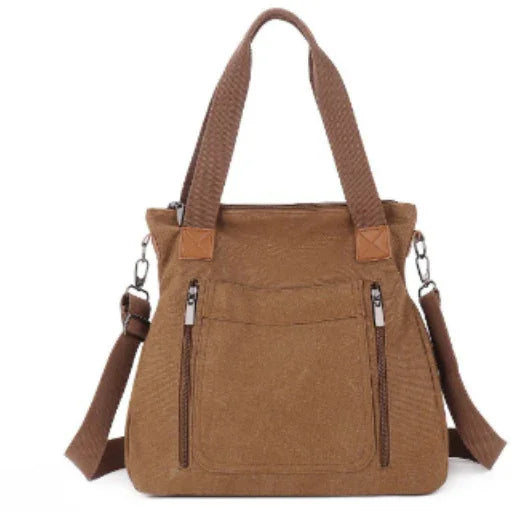 brown canvas tote bag with dual top handles, front zip pockets, and adjustable shoulder strap