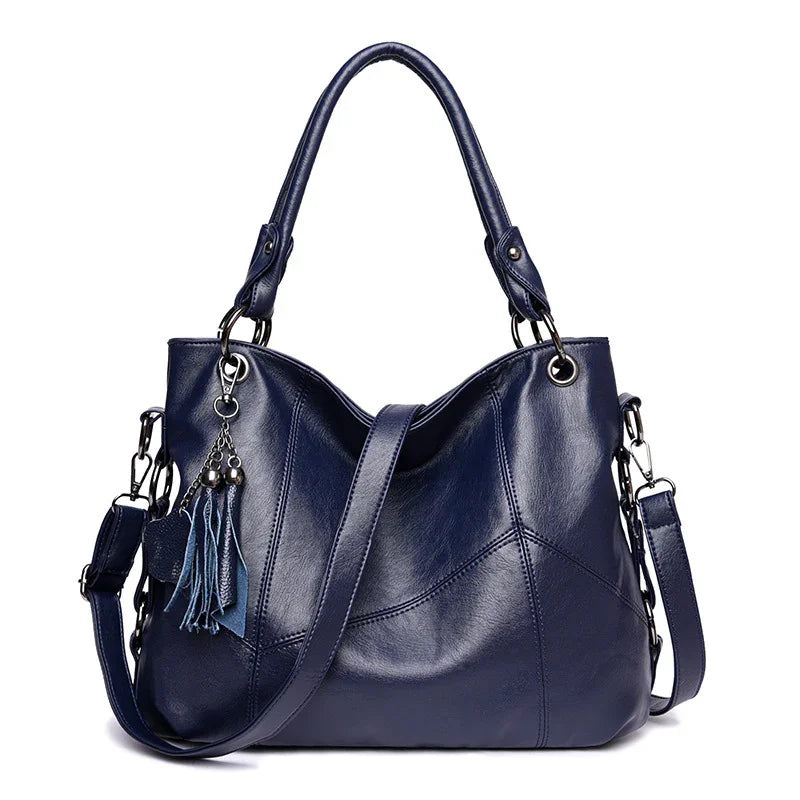 Stylish navy blue leather handbag with dual handles, detachable shoulder strap, and tassel charm