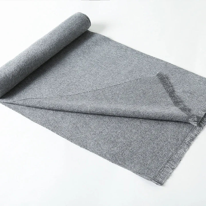 Rolled grey fabric textile with folded layered texture on white background