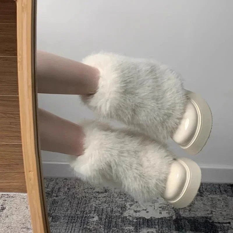 White fluffy fur slippers with thick soles worn indoors on carpeted floor