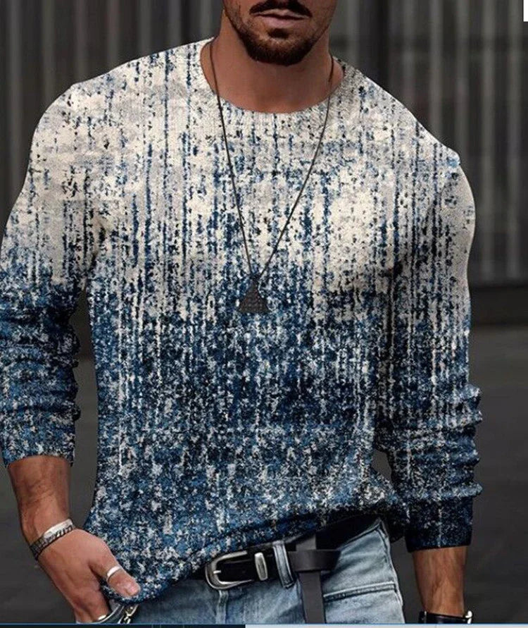 Man wearing blue and white textured knit sweater with pendant necklace and light blue jeans
