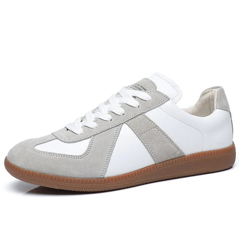 White and grey suede low-top sneaker with gum sole and white laces on white background