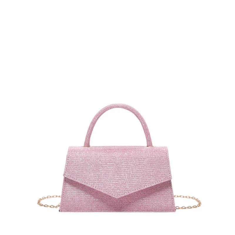 Elegant pink textured handbag with top handle and gold chain strap on white background