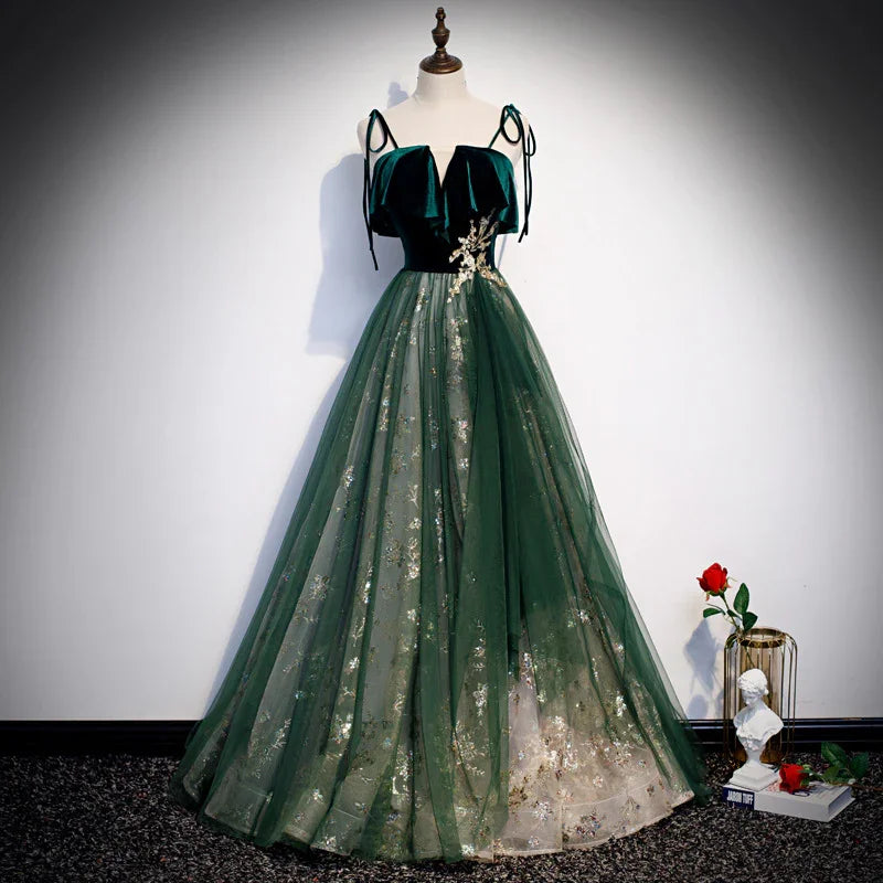 Elegant dark green velvet and tulle formal gown with floral embroidery displayed on mannequin