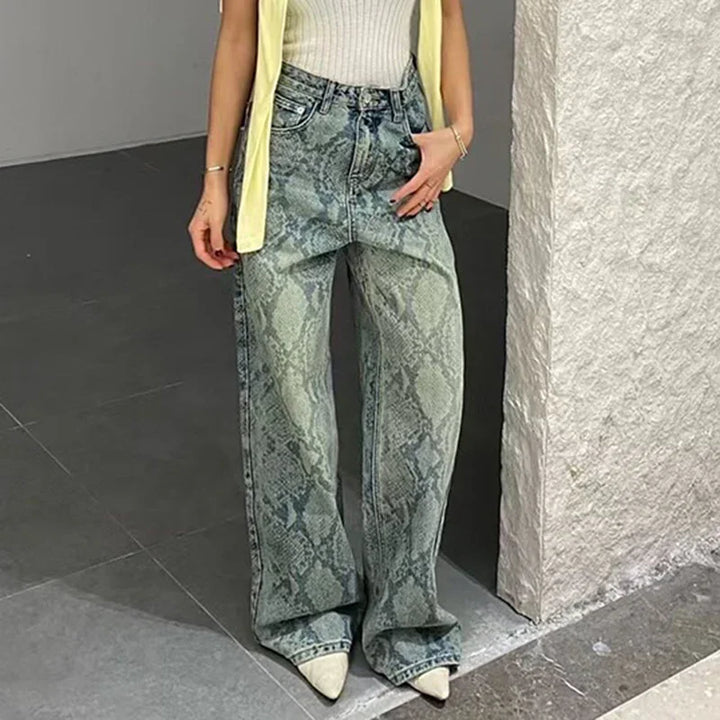 Woman wearing high-waisted wide-leg snake print jeans with white pointed shoes and light yellow sleeveless top