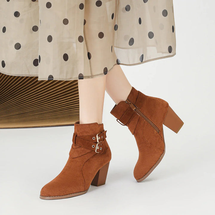 Brown suede ankle boots with block heels and double buckle straps worn with sheer polka dot skirt