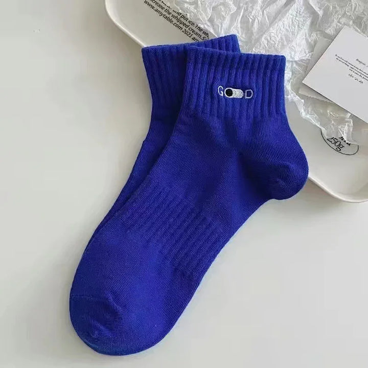 Pair of royal blue ankle socks with ribbed cuffs and white embroidered 'GOOD' text