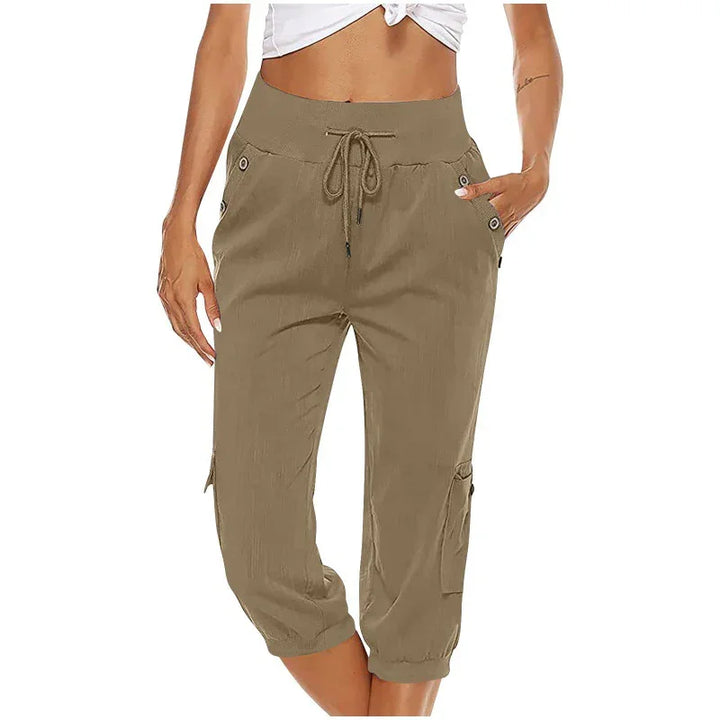 Woman wearing khaki cropped cargo pants with drawstring waist and pockets, paired with a white cropped top