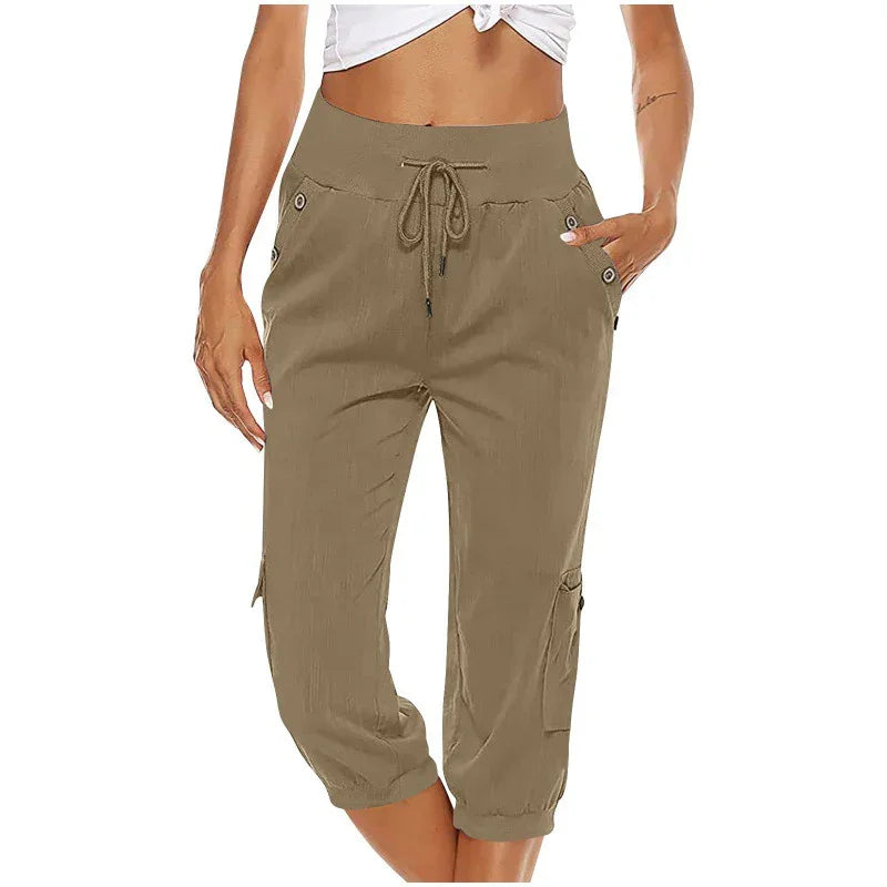 Woman wearing khaki capri cargo pants with drawstring waist and pockets, paired with white cropped top