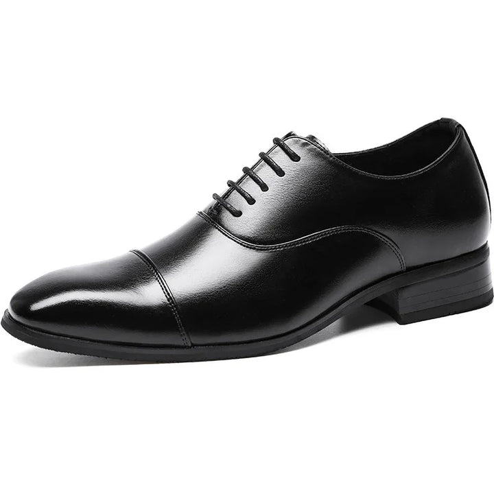 Black leather men's dress shoe with cap toe and lace-up detailing on white background