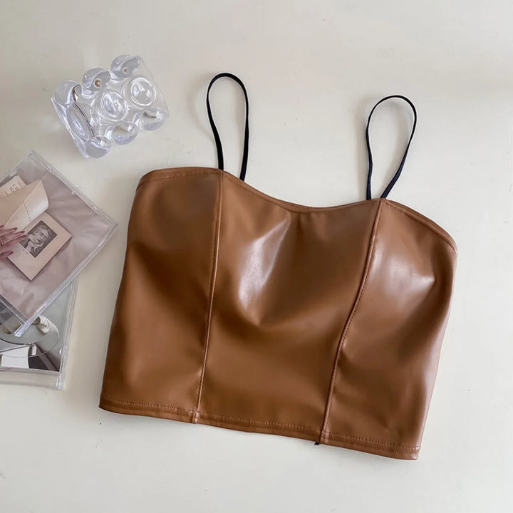 Brown faux leather cropped camisole with black spaghetti straps on white surface