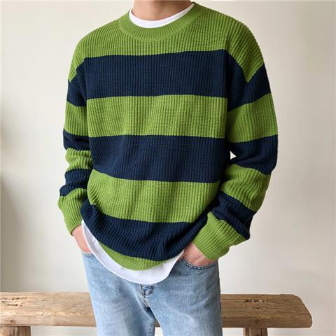 Man wearing green and navy blue striped knitted sweater with light blue jeans and white undershirt