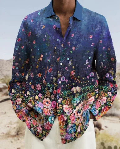 man wearing blue floral gradient shirt with multicolor flowers standing in desert landscape