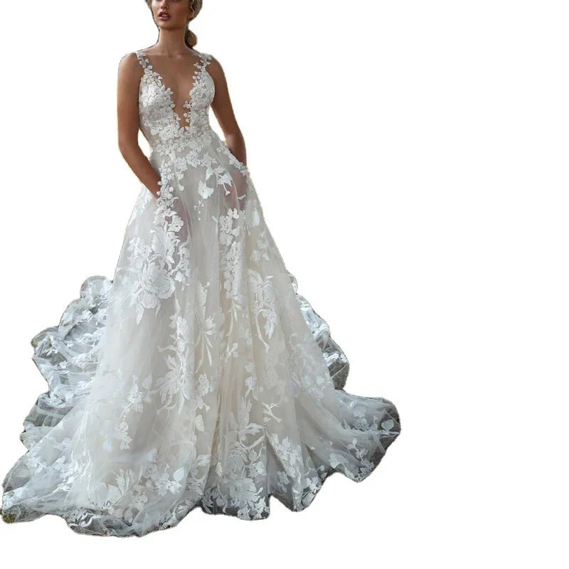 Elegant white bridal gown with floral lace appliqué and deep V-neckline on model