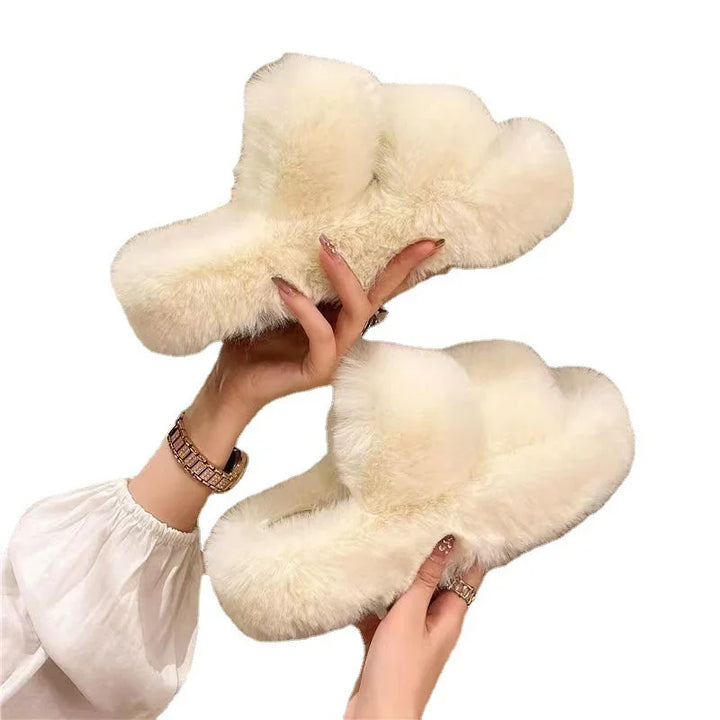 hands holding soft fluffy white fur slippers with cozy design on white background