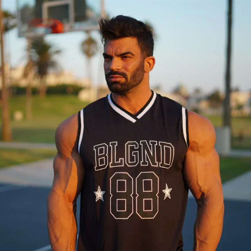 Muscular man wearing black sleeveless BLGND 88 basketball jersey outdoors at sunset