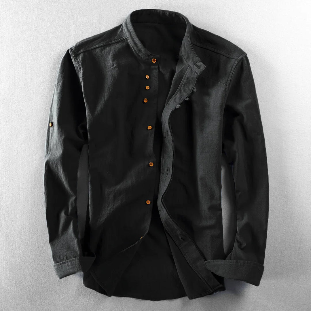 Black mandarin collar shirt with long sleeves and brown buttons on a light surface