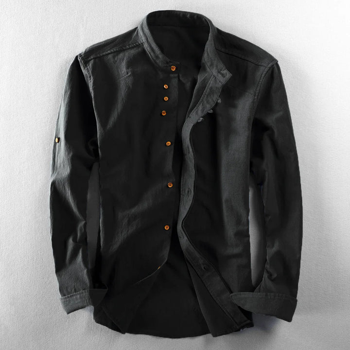 Black mandarin collar shirt with long sleeves and brown buttons on a light surface