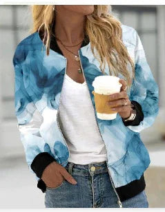 Woman wearing blue watercolor patterned bomber jacket holding a coffee cup, casual street style