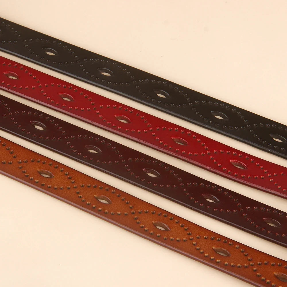 Four decorative leather belts in black, red, dark brown, and tan with embossed patterns