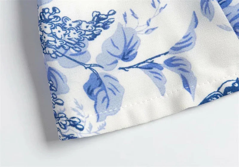 Close-up of white fabric with blue floral leaf pattern and stitched hem detail