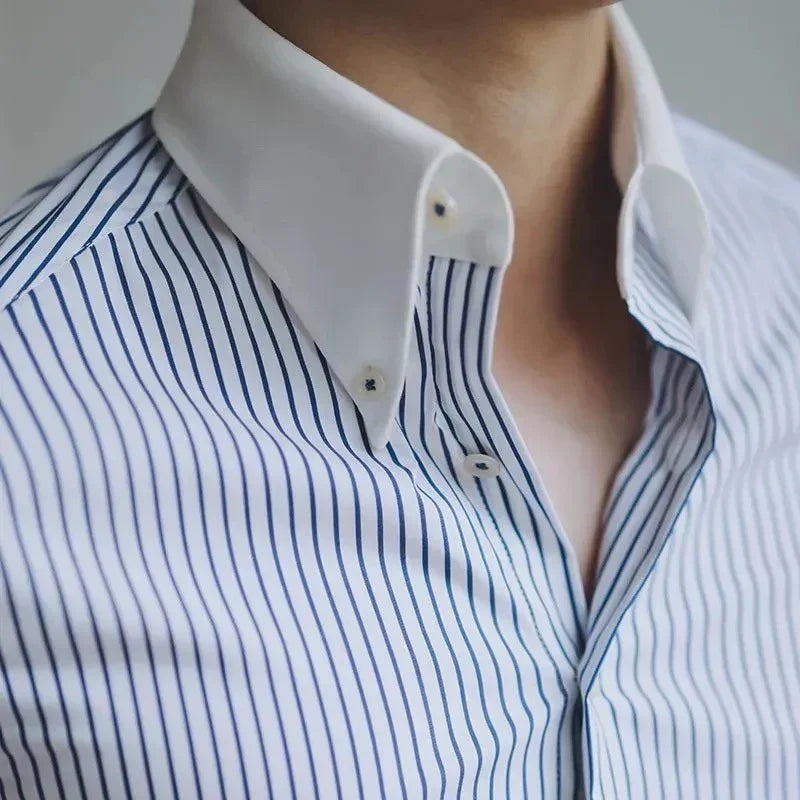 Close-up of a men's white dress shirt with blue vertical stripes and a contrasting white button-down collar