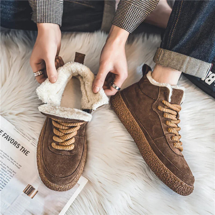 Brown suede winter boots with warm white fleece lining and thick laces, worn on white furry rug