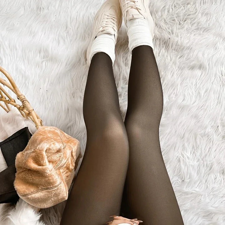 Legs wearing sheer black tights and white casual shoes on a fluffy white rug with a tan fur bag nearby