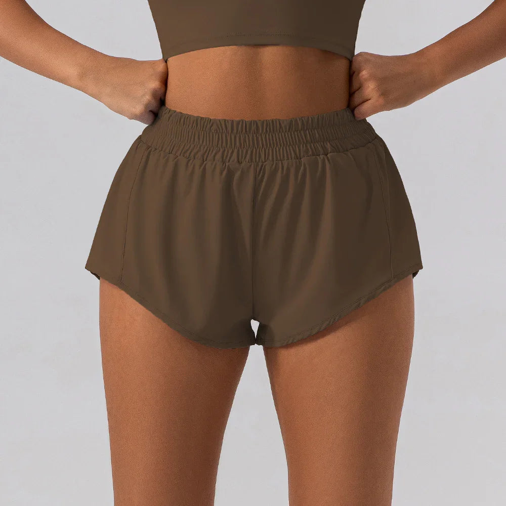 Close-up of woman wearing brown high-waisted athletic shorts with elastic waistband