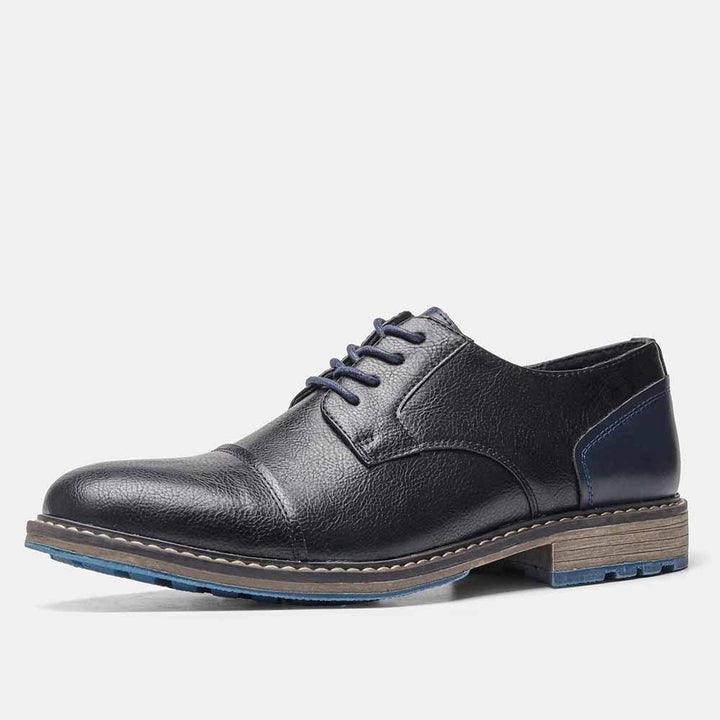 Black leather men's dress shoe with navy heel accent and blue lace-up detail on white background