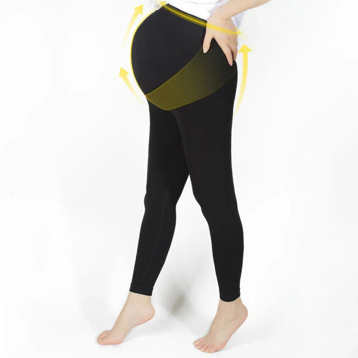 Pregnant woman wearing black maternity leggings with yellow arrows showing belly support and lift